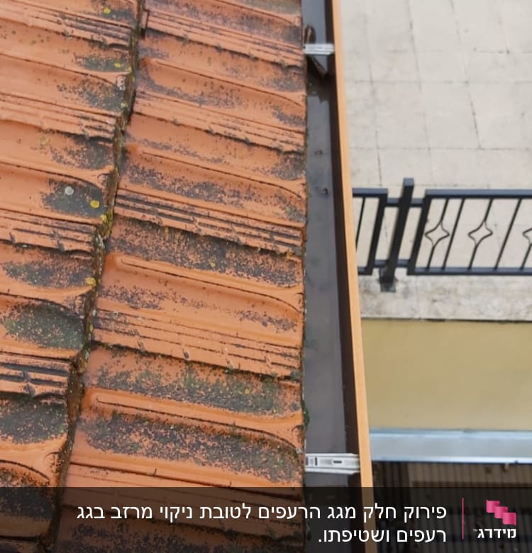 מרזב מתכת ליד גג רעפים אדום